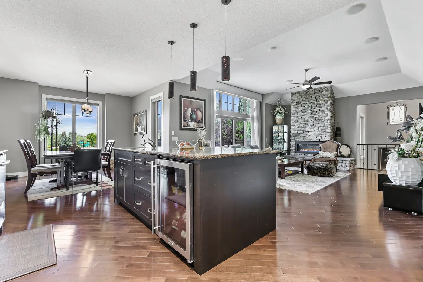 A wide view over the island to the dining nook and great room, west light pouring through every window on the main floor.