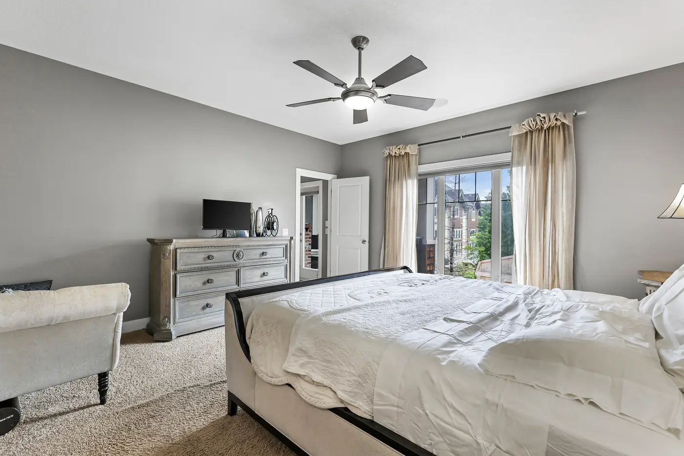 The primary bedroom looking toward its glass doors, which open directly onto the covered patio and its outdoor fireplace.