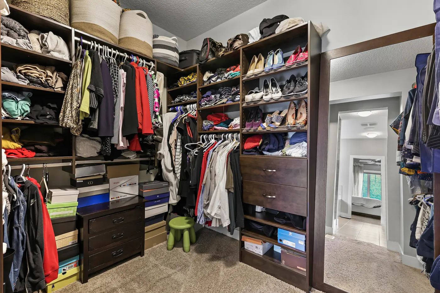 The walk-in closet off the ensuite, floor-to-ceiling shelving and double hanging rails on both sides.