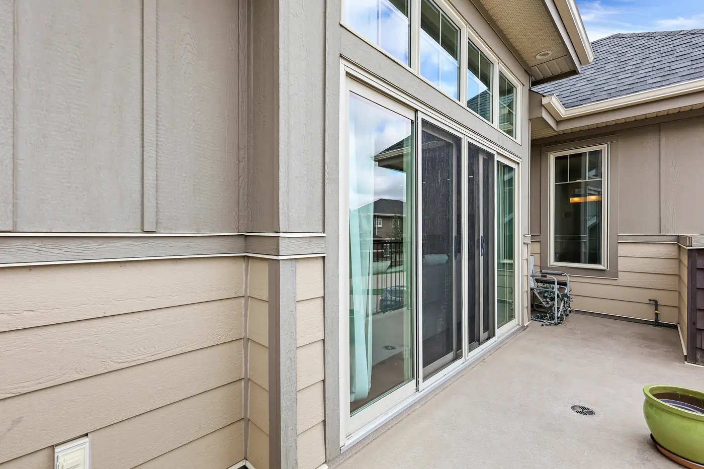 The sliding glass wall between the primary retreat and the covered patio, transom glazing carrying light deep into the house.