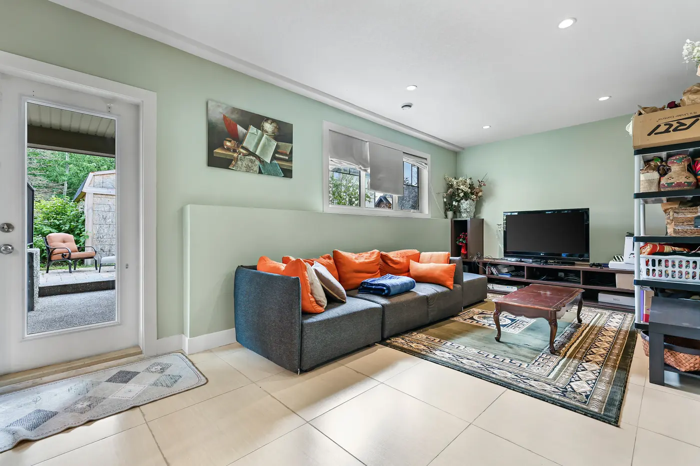 The walkout family room, daylight from the patio door and full-size windows — nothing about it feels like a basement.