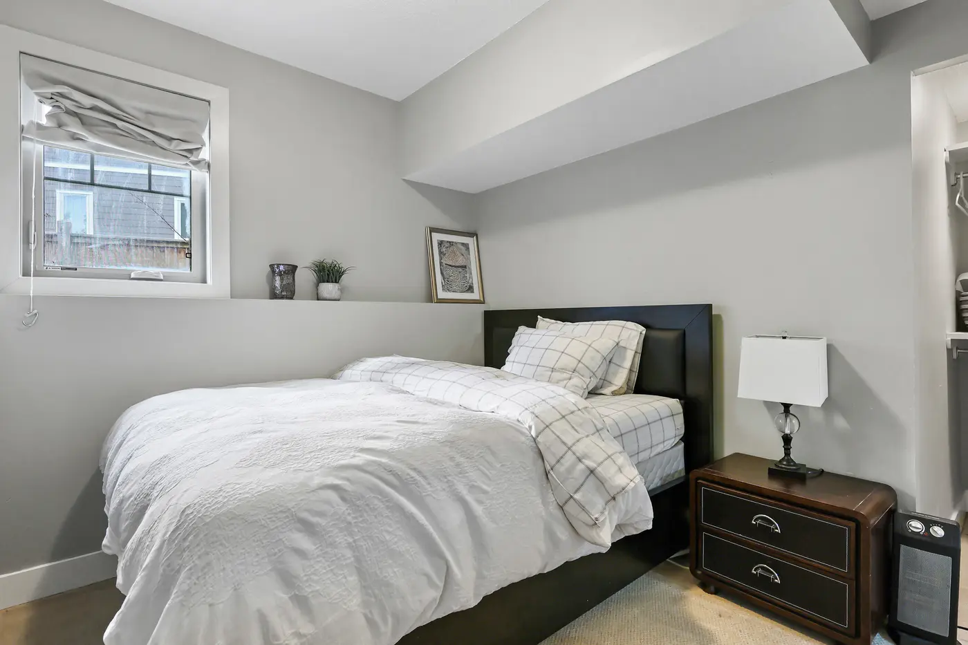 The fifth bedroom on the walkout level, a full-size window keeping it bright.