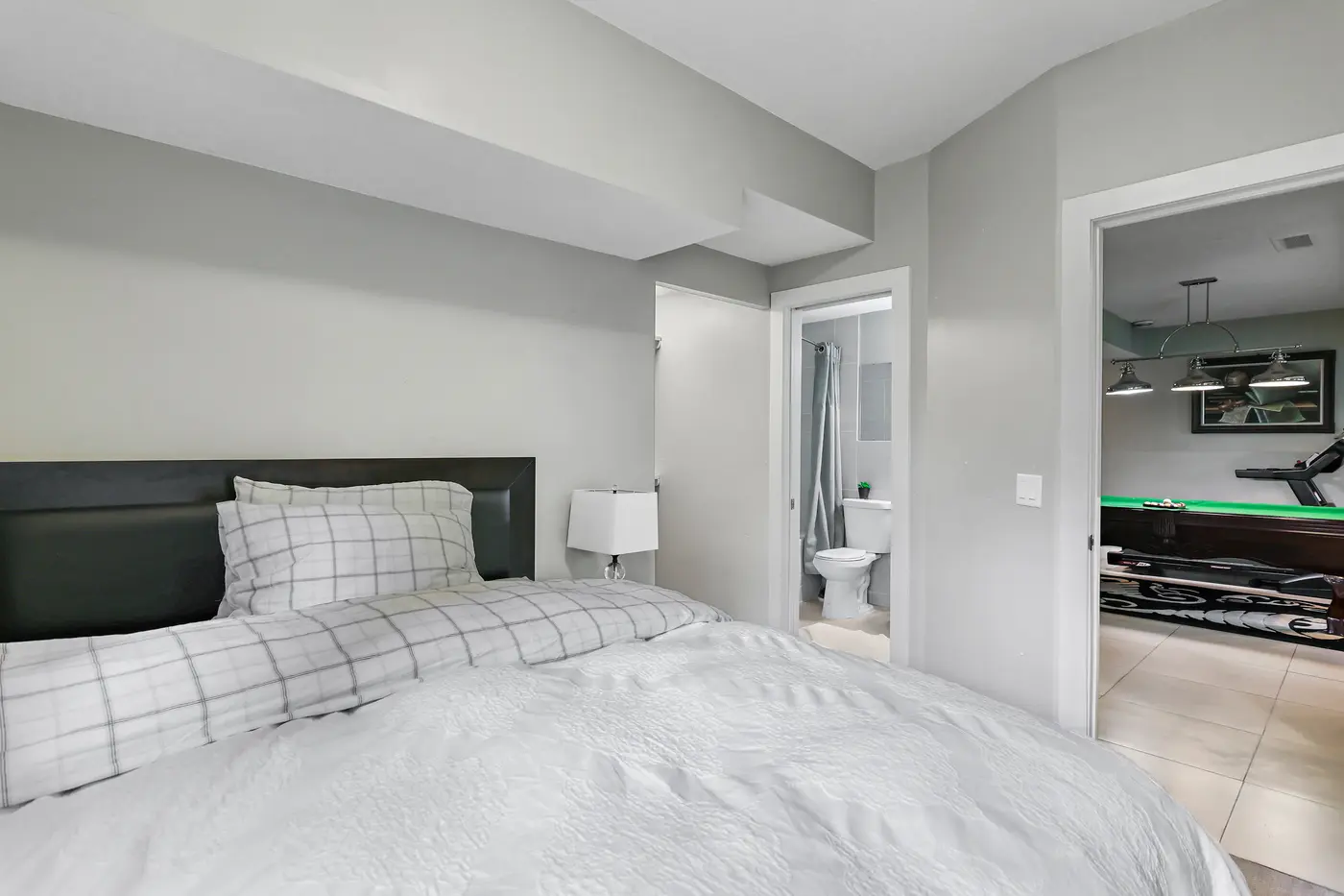 The walkout bedroom looking out to its adjacent four-piece bathroom and the game room across the hall.