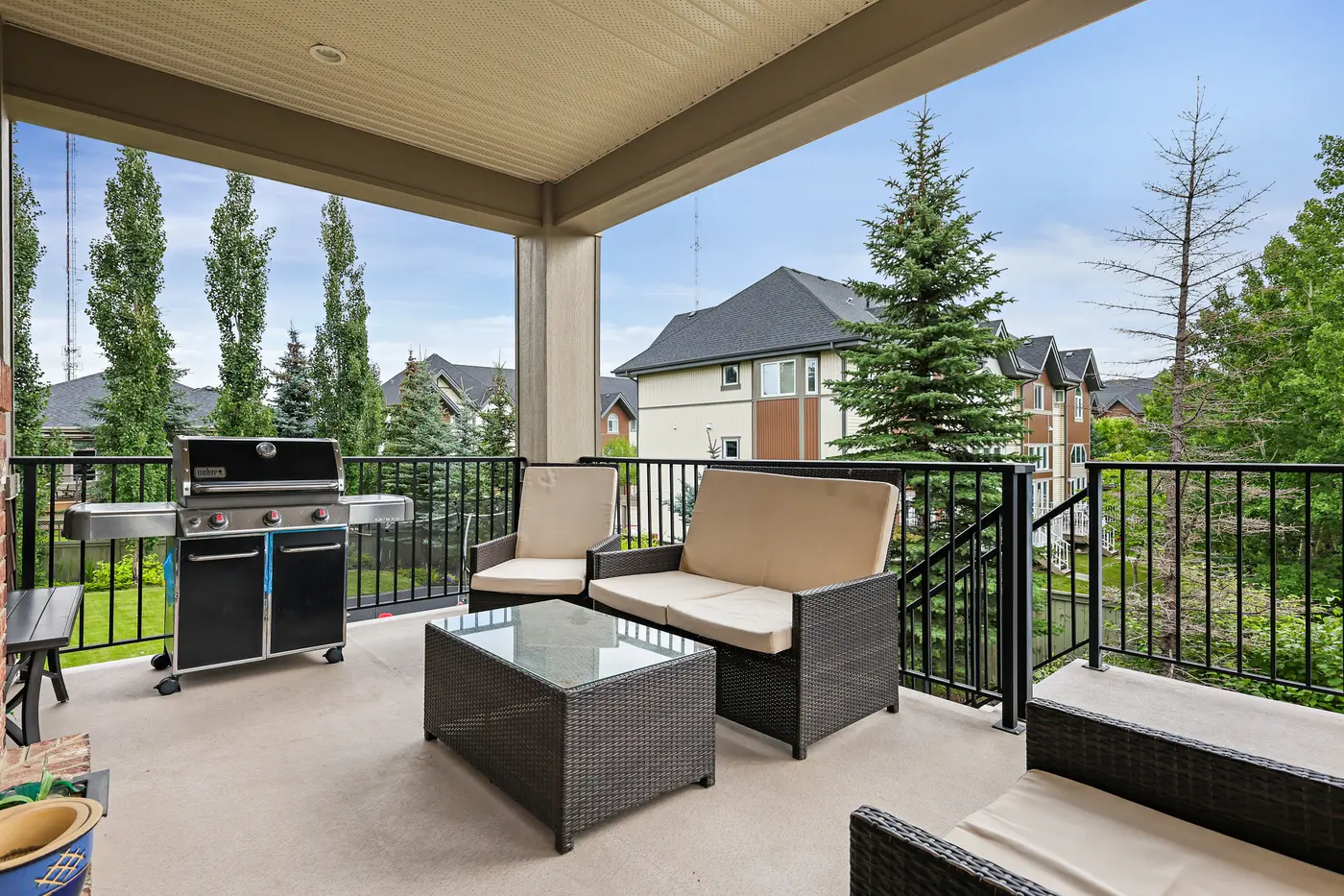The upper deck with barbecue and conversation set, looking over the backyard trees to the rooftops of West Springs.