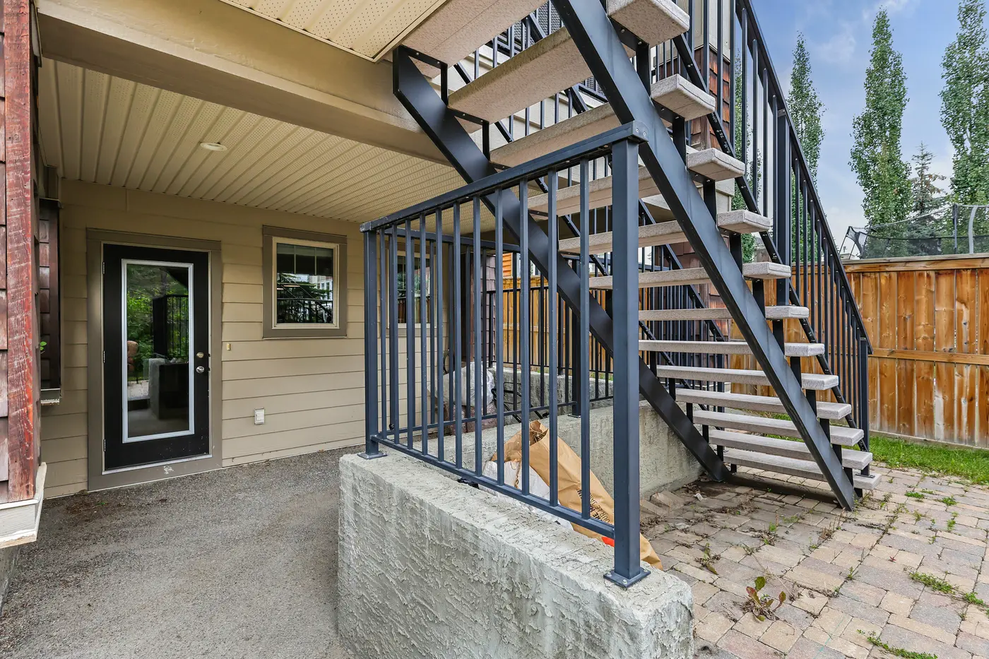 The open-riser staircase from the upper deck down to the walkout patio and backyard.